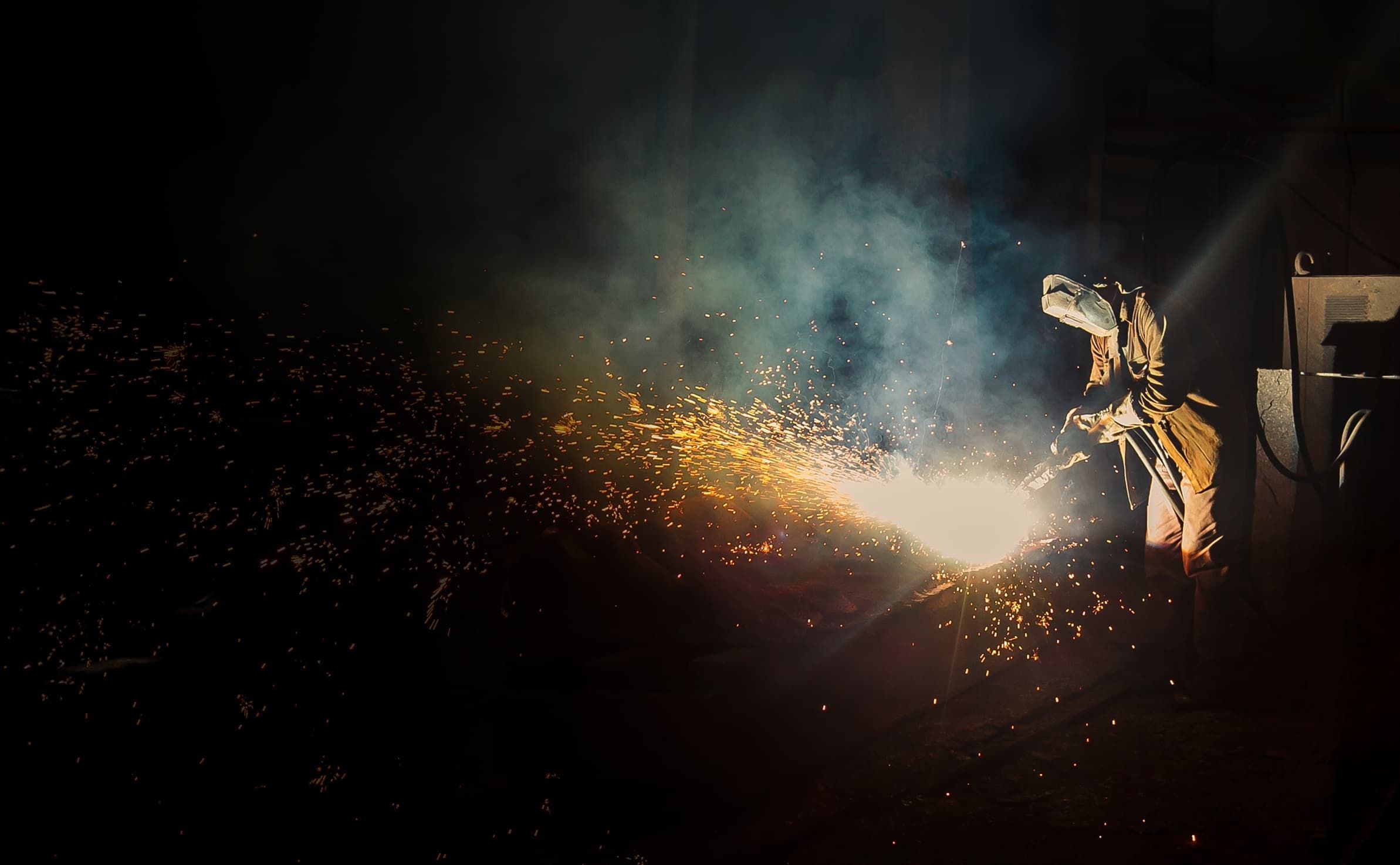 Ein Schweißer in voller Schutzausrüstung bei der Arbeit.